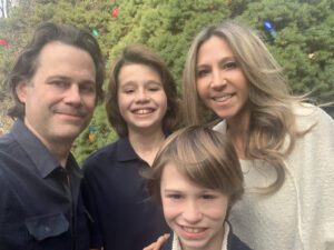 MCF Director of Donor & Giving Partner Engagement poses with her husband and sons.
