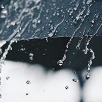 black umbrella in falling rain