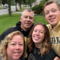 Christine Barden and her husband, son and daughter pose for a selfie on their front lawn.