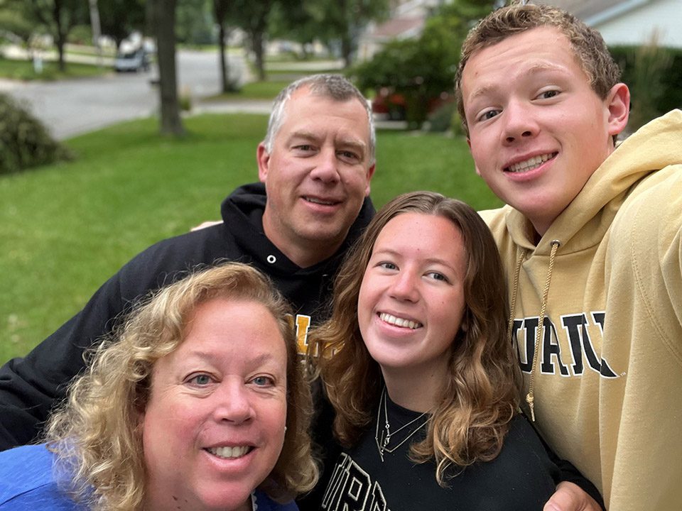 Christine Barden and her husband, son and daughter pose for a selfie on their front lawn.
