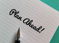 Photo of an open notebook and pen with the words "Plan Ahead!" written in script.