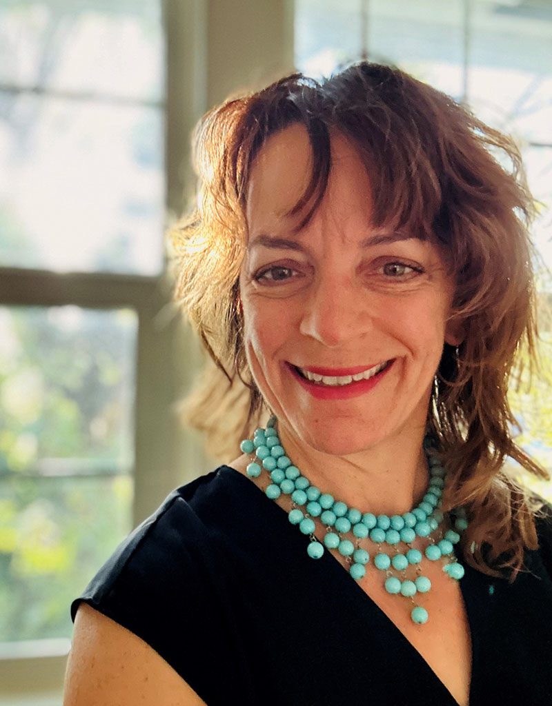 Headshot photo of Jeneen Hartley wearing a black top with a turquoise necklace.
