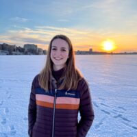 Candid photo of Catherine Frerker at sunset in the winter with the Madison skyline behind her.
