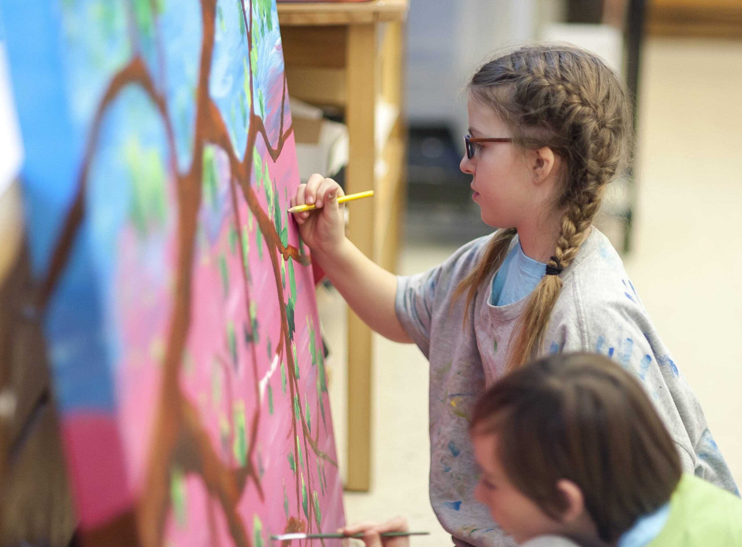 a young girl very focused on a painting