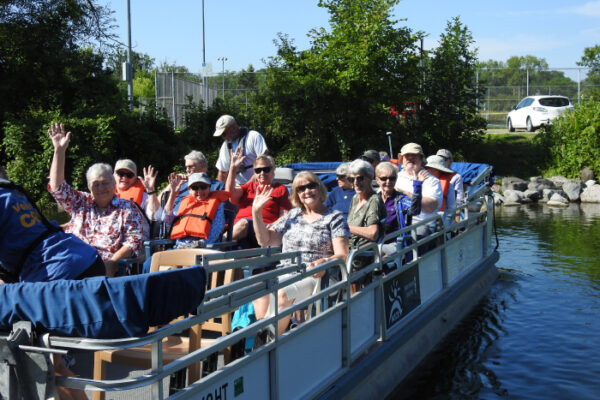 A group of older community members enjoy a pontoon ride