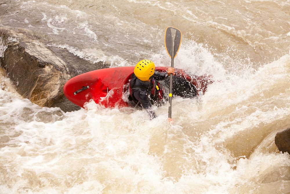 Image of a person in a red kayak negotiating rough waters.