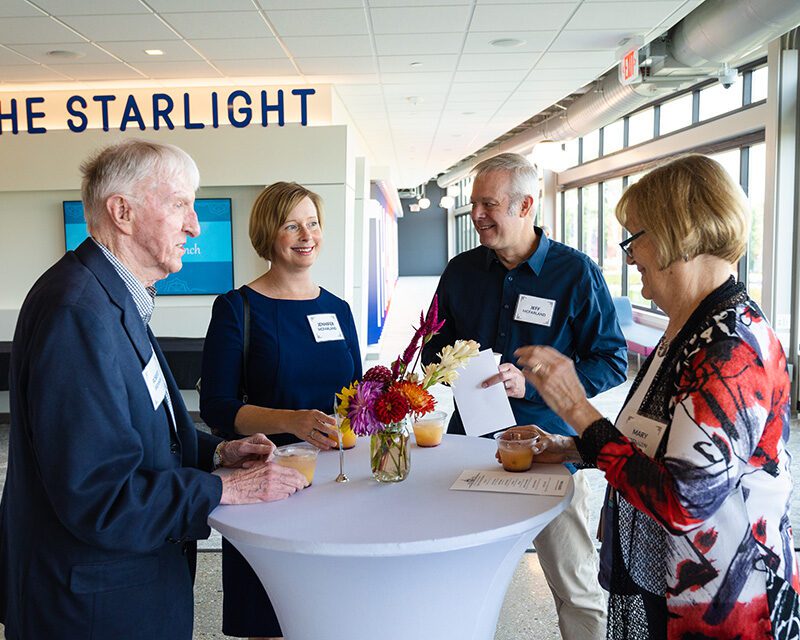 A group of four people chatting at a table at the 2022 Legacy Society brunch