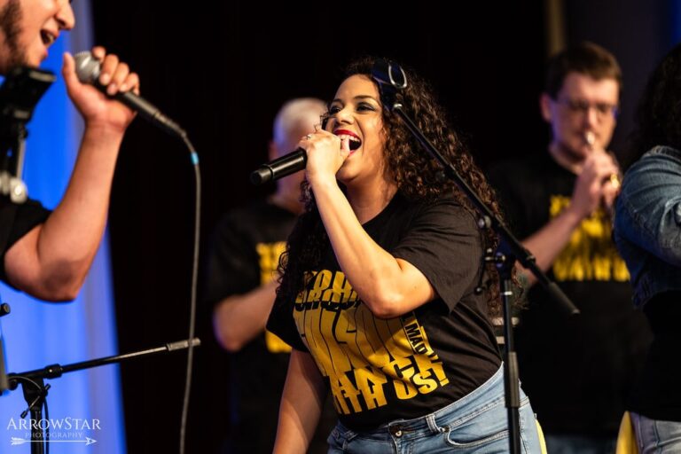 Woman sings passionately into microphone