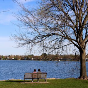 Couple sits on bench overlooking Monona Bay