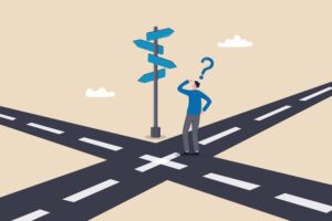 Cartoon man standing at a crossroads trying to decide which way to go