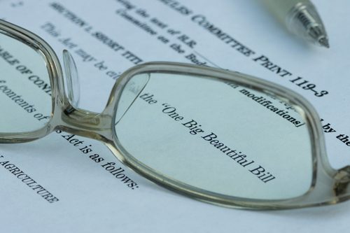 Glasses sitting on a paper that says "One Big Beautiful Bill"