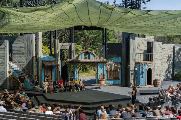 a cast sits on stage to answer questions after a performance