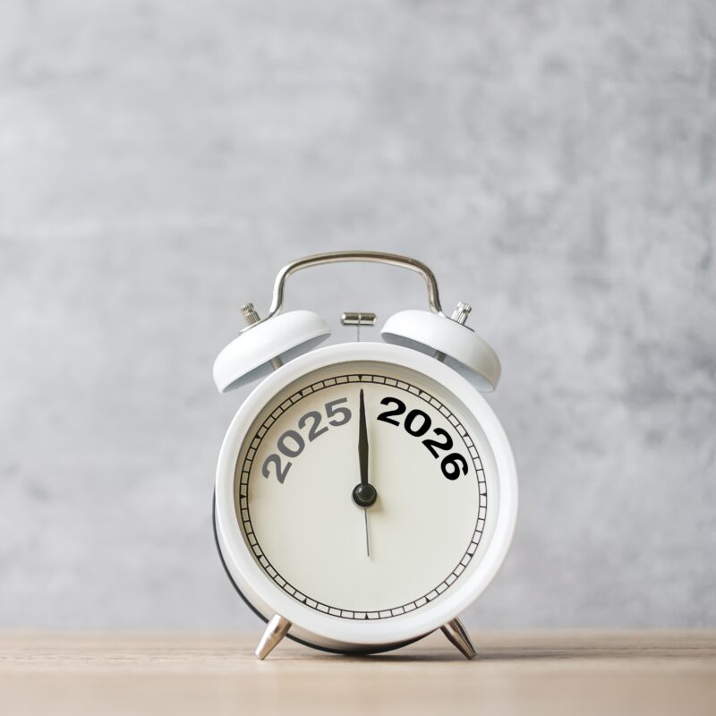 A white clock turning from the year 2025 to 2026