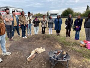 TFN PLACES cohort stand around a fire pit in Sacramento as they learn about the Indigenous history of the area