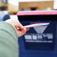 Person putting mail in post box