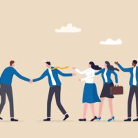 People shaking hands with group behind them