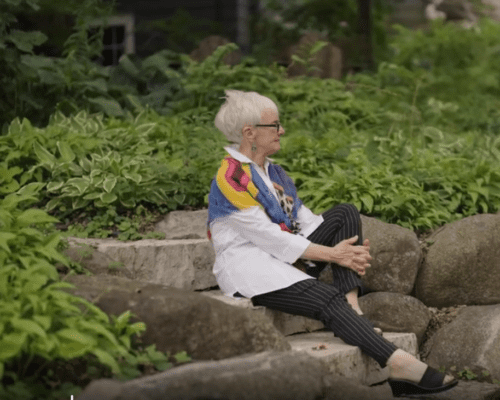 Barbara Johnson sits on steps outside her home